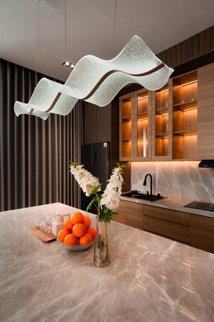 A sleek, contemporary kitchen in Jakarta highlighted by elegant lighting and marble countertops.